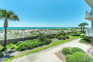 A beachfront property with a paved walkway, palm trees, and a view of the ocean. - 🌊BEACH Front Corner Unit~Free Beach Service~Pool~3BR Island Princess 200🌅 (Fort Walton Beach)