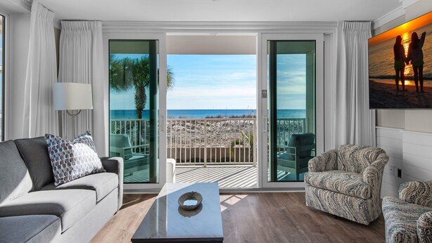 A modern living room with a view of the beach, a ceiling fan, and a large window. - 🌊BEACH Front Corner Unit~Free Beach Service~Pool~3BR Island Princess 200🌅 (Fort Walton Beach)