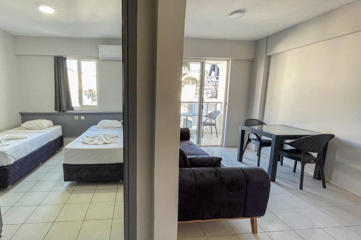 Quarto de hotel com duas camas, uma mesa de jantar e um sofá.