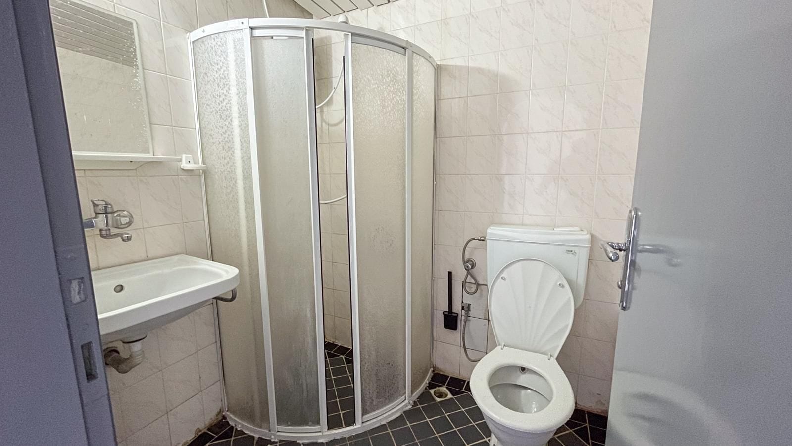 Appartement | Badkamer | Een douche, pantoffels, handdoeken, toiletpapier
