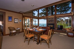 A spacious living area with a large dining table, comfortable seating, and a fireplace. - Sea Cliff - Perched above Sea, Romantic & Private! (Trinidad)