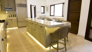 A kitchen with a large island, wooden cabinets, and a built-in stove.