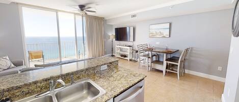 A modern kitchen with granite countertops, stainless steel appliances, and a dining area with a table and chairs.