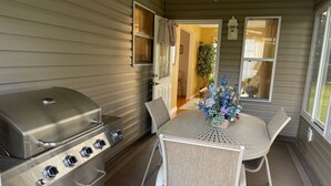 A patio with a grill, a table with chairs, and a potted plant. - Chic Gem in The Villages - Modern Amenities & Prime Location! Call today! (The Villages)