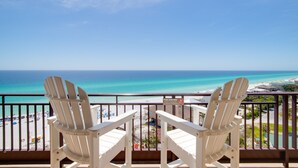 Two white Adirondack chairs facing a beach with a clear view of the ocean and a sign on the balcony railing. - Fully Remodeled Modern Condo ~ Golf Cart (Miramar Beach)