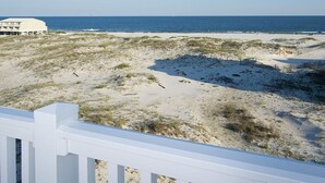 A beach view with a white building and a sandy landscape. - Grace | 6BR Fort Morgan Beach Retreat | Pet-Friendly | Gulf View (Gulf Shores)