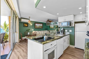 A modern kitchen with white cabinets, a microwave, and a built-in oven.
