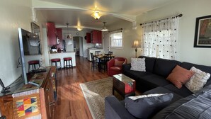 Un espacio habitable amplio con un sofá, una mesa de comedor y una cocina al fondo.