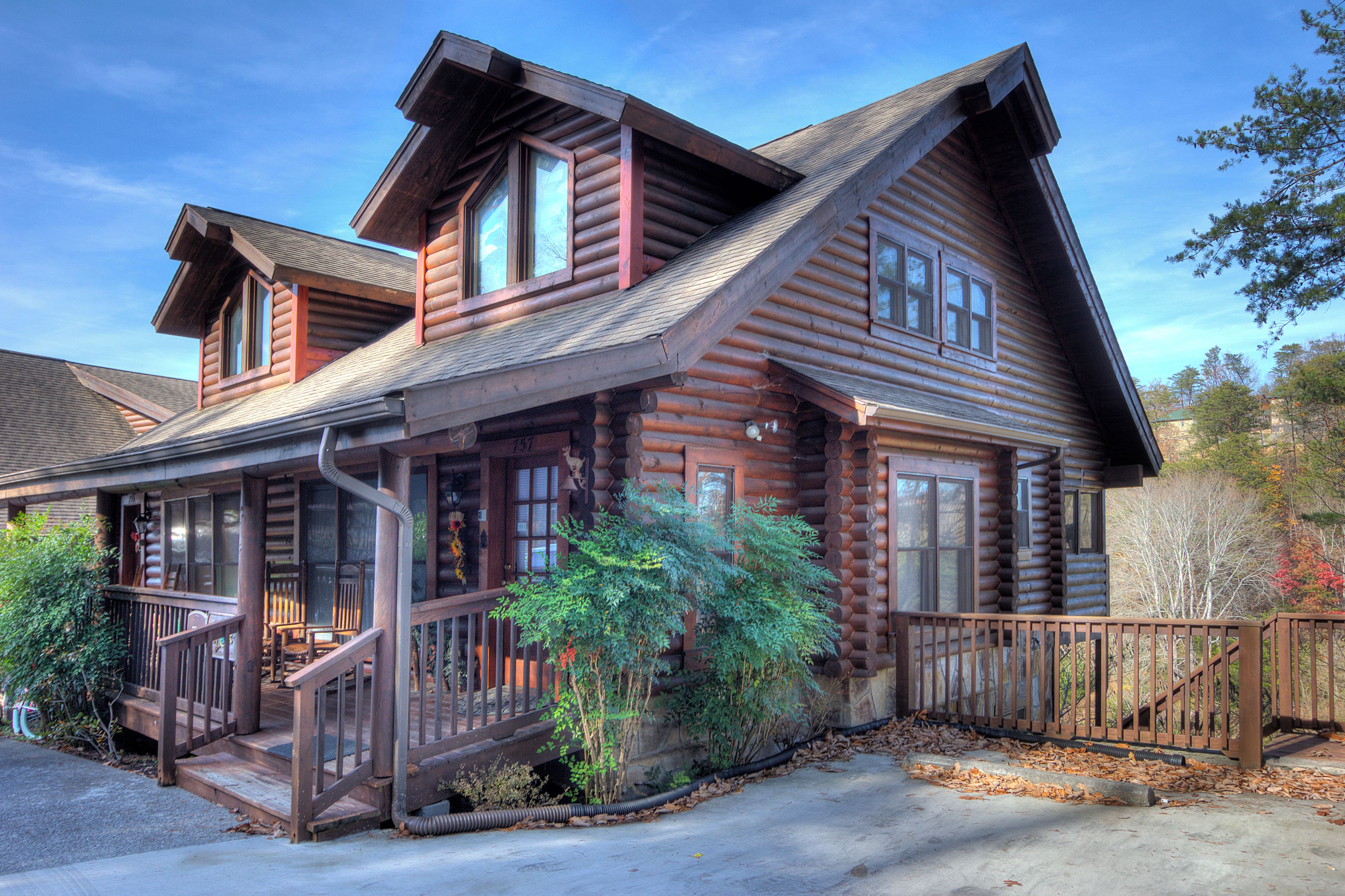 A log cabin with a porch, multiple windows, and a staircase leading to the entrance.