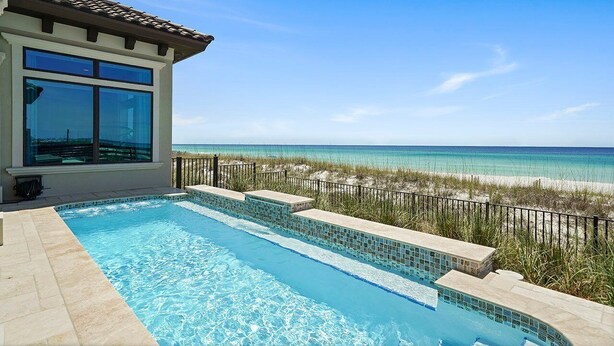 A swimming pool with clear blue water, a view of the ocean, and a beach in the background. - Verona - Huge Ocean Front Home in Gulf Pines with Private Pool & Beach Access (Miramar Beach)