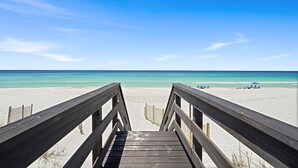 A wooden boardwalk leading to a beach with clear turquoise water and a clear sky. - Verona - Huge Ocean Front Home in Gulf Pines with Private Pool & Beach Access (Miramar Beach)