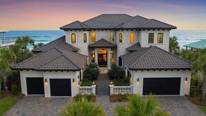 A large, two-story house with a tiled roof, a central entrance, and two garage doors. - Verona - Huge Ocean Front Home in Gulf Pines with Private Pool & Beach Access (Miramar Beach)