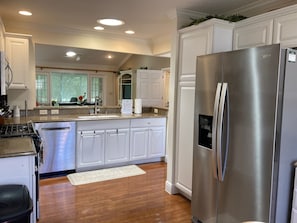 Una cocina moderna con armarios blancos, electrodomésticos de acero inoxidable y una isla central.
