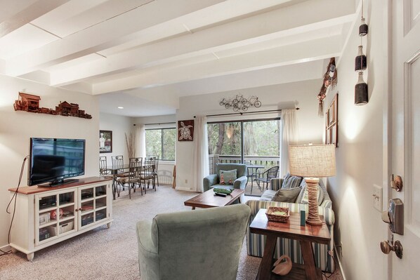 A spacious living room with a television, dining area, and seating. - Racquet Club Villas 2321- Charming Sea Pines 1 bedroom plus Bonus Loft!! (Hilton Head Island)