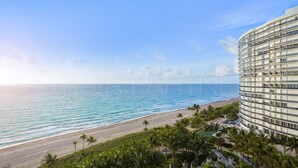 A beachfront hotel with a curved exterior, a pool area, and a beach view. - Most Luxury hotel 5 stars oceanfront w. balconies - Valet & Amenities included (Bal Harbour)