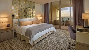 A modern hotel room with a large bed, a desk, and a balcony with a view. - Most Luxury hotel 5 stars oceanfront w. balconies - Valet & Amenities included (Bal Harbour)