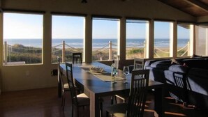 A dining area with a view of the ocean and hills.