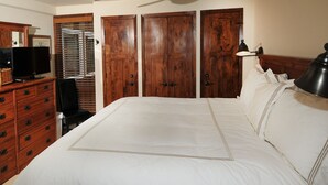 A bedroom with a large bed, wooden wardrobe, a television on a dresser, and a window with blinds. - Perfect Views and Location in Lionshead! Well Appointed Condo Steps from Lifts (Vail)