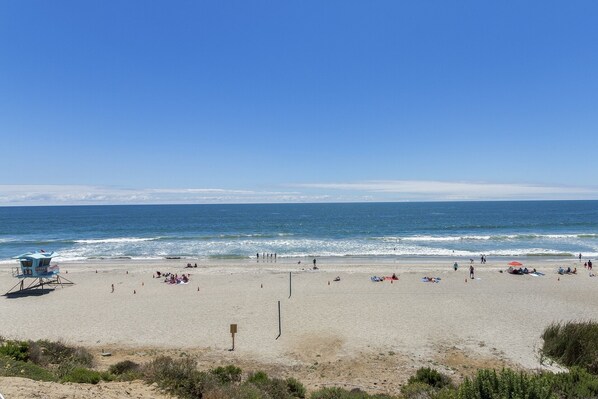 A beach with a lifeguard tower, sandy beach, and ocean view.