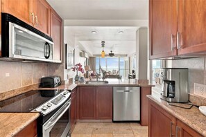 Una cocina moderna con horno integrado, lavavajillas y cafetera.