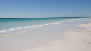 A beach with clear turquoise water and white sand.