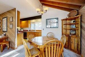 Cozy dining area with a large table and matching chairs, surrounded by rustic charm and warm lighting.