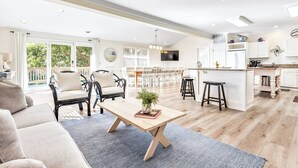 A spacious living area with a wooden coffee table, a sofa, and a dining set.