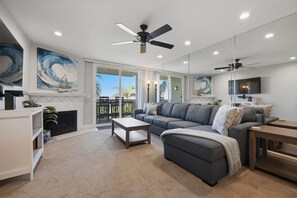 A modern living room with a sectional sofa, a coffee table, and a ceiling fan.