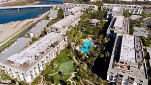 A high-rise hotel with multiple balconies, a swimming pool, and a view of a river. - Ocean View-Close to Beachfront Cottages. E105 North Coast Village (Oceanside)
