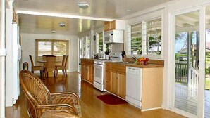 A spacious kitchen with wooden cabinets, a microwave, and a dishwasher. There is a dining area with chairs and a table.
