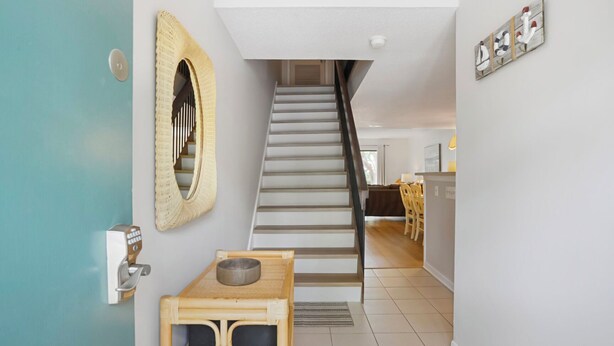 A staircase leading to a dining area with a table and chairs. - Surf Court 70 - Forest Beach Townhouse (Hilton Head Island)