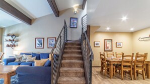 A staircase leading to a dining area with a wooden table and chairs. - Walk to Ski Condo, Pool, Spa, Gym, Tennis 398 (Mammoth Lakes)
