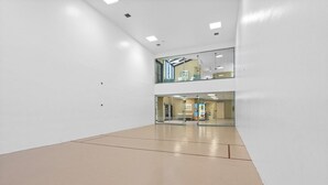Un espacio interior amplio y luminoso, con techo alto y piso pulido.