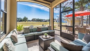 A covered outdoor seating area with a view of a golf course.