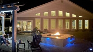 A modern house with a patio area featuring a fire pit and outdoor seating. - Newmans Beachview 3 bedrooms, 3 bathrooms (Jekyll Island)