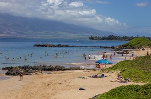 Enjoy a lively beach scene with calm waters, perfect for relaxation and water activities.