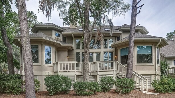 A large, multi-story house with a prominent balcony and multiple windows. - 69 Shell Ring - Nestled in A Quiet Sea Pines Community offering Pool & Tennis (Hilton Head Island)