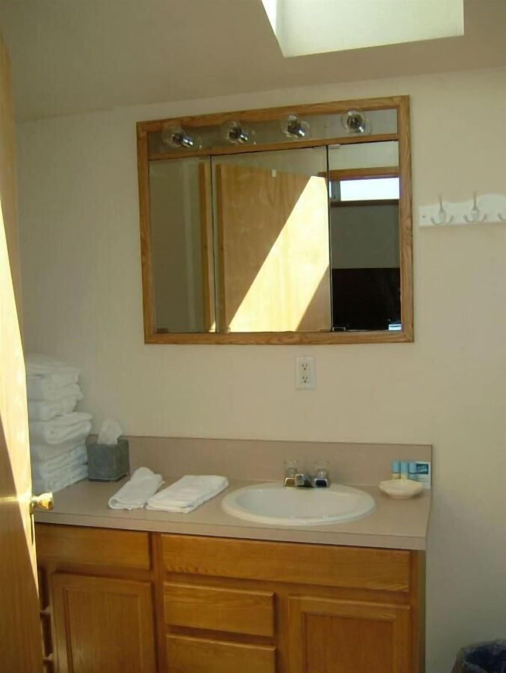 Une salle de bain avec un meuble-lavabo en bois, un évier et un miroir.