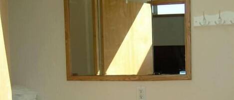 Une salle de bain avec un meuble-lavabo en bois, un évier et un miroir.
