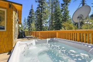 A hot tub on a wooden deck with a wooden house and a satellite dish in the background. - Alpine Adventure by Tahoe Getaways - Ski Shuttle, Hot Tub + Pet Friendly (Olympic Valley)