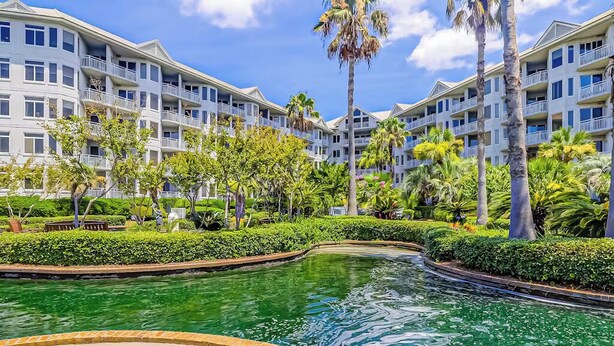 A hotel with a pool, surrounded by palm trees and greenery. - Sea Crest 2509 - Beautiful 5th Floor Condo with Breathtaking Ocean Views! (Hilton Head Island)
