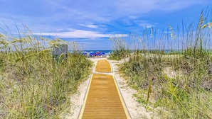 A wooden pathway leading to a beach area with sand and grass on either side. - Sea Crest 2509 - Beautiful 5th Floor Condo with Breathtaking Ocean Views! (Hilton Head Island)