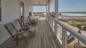A wooden deck with outdoor seating, overlooking a beach and a clear sky. - Seaspray 7bed7.5B, Grayton, pool,Gulf /Lake view,DOCK,playroom!Red Bar! (Santa Rosa Beach)