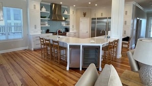 A spacious kitchen with a central island, white cabinetry, and a wooden floor. - Seaspray 7bed7.5B, Grayton, pool,Gulf /Lake view,DOCK,playroom!Red Bar! (Santa Rosa Beach)