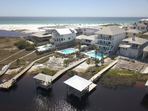 A coastal hotel with multiple buildings, a swimming pool, and a dock area.