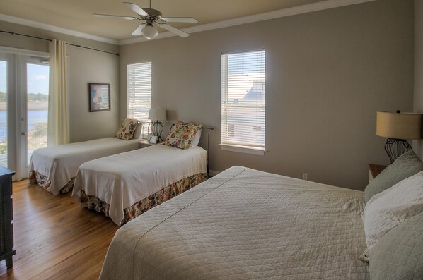 A bedroom with two beds, a ceiling fan, and a view of the outdoors. - Seaspray 7bed7.5B, Grayton, pool,Gulf /Lake view,DOCK,playroom!Red Bar! (Santa Rosa Beach)