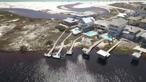 An aerial view of a coastal property with multiple buildings, a swimming pool, and a beach. - Seaspray 7bed7.5B, Grayton, pool,Gulf /Lake view,DOCK,playroom!Red Bar! (Santa Rosa Beach)