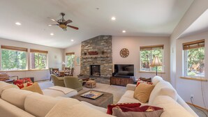 A spacious living room with a stone fireplace, comfortable seating, and large windows. - Luxury Family Home, Hot Tub, Garage, Family Room, Near Tahoe City in Carnelian Bay (Carnelian Bay)