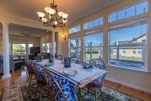 A spacious dining area with a large table, chairs, and a chandelier. - Garden Pond Retreat~Hot tub & Fire Pit! (Mckinleyville)
