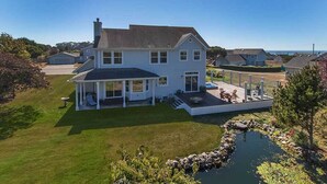 A two-story house with a covered porch, a small deck, and a pond. - Garden Pond Retreat~Hot tub & Fire Pit! (Mckinleyville)
